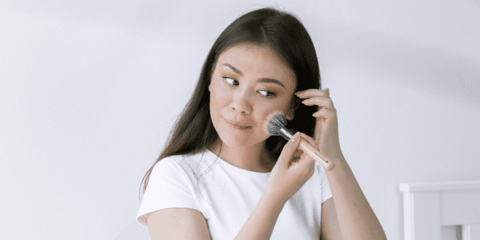 woman applying makeup on face